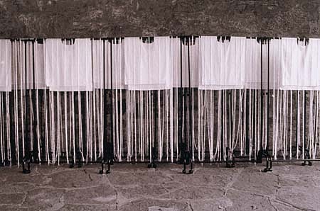 Helène Aylon
The Partition is in Place, But The Service Can't Begin, 2001
metal racks, thread, ritual male garb (Tsitsit), 21' W x 2' D x 6' H